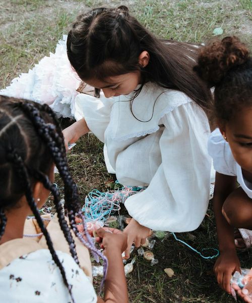 Group of diverse children laughing while sitting on yoga mats in a circle.